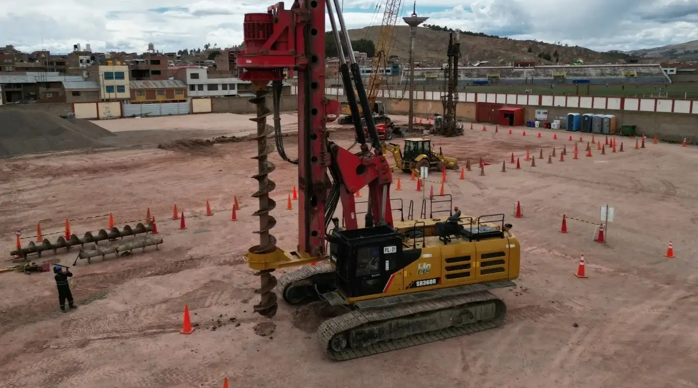 Perforadora con barrena helicoidal continua ejecutando un pilote CFA, con barrenas de repuesto en el frente