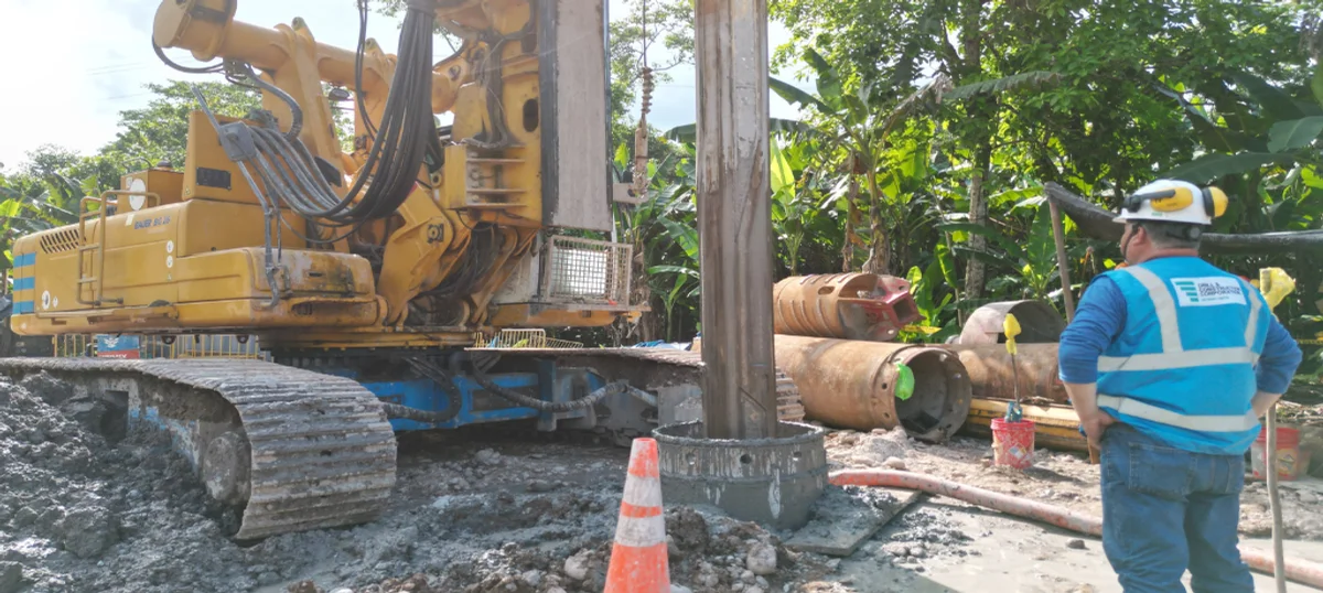 Perforadora rotativa con trépano helicoidal ejecutando pilote excavado en obra de puente andino en Perú