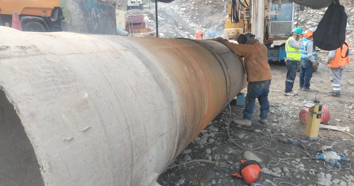 Casing metálico recuperable apoyado en la plataforma de trabajo, con la cuadrilla al lado dando la escala del tubo