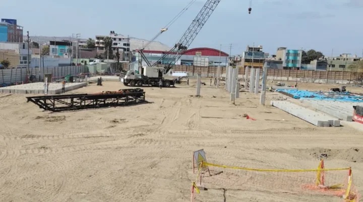 Vista general de la obra del Colegio Politécnico del Santa en Chimbote, con dos grúas de orugas y los marcos de hincado sobre la plataforma de trabajo