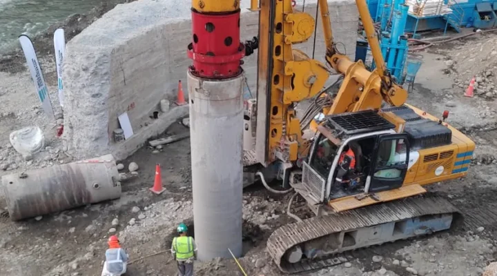 Perforadora ejecutando un pilote excavado con casing metálico en el cauce del río, en la obra del Puente Victoria en San Ramón
