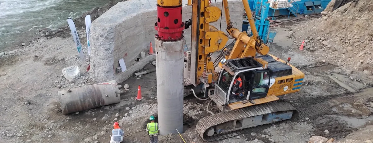 Perforadora ejecutando un pilote excavado con casing metálico en el cauce del río, en la obra del Puente Victoria en San Ramón