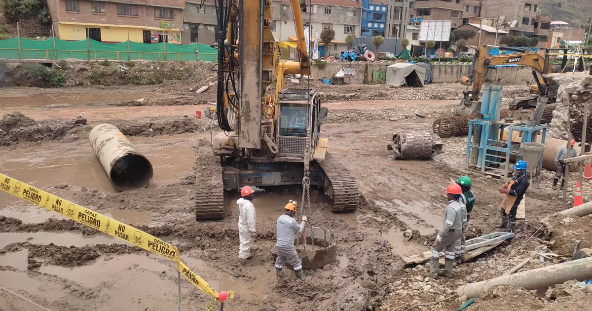 Perforadora sobre orugas en la boca de un pilote excavado del Puente Sinchi Roca, con la cuadrilla en el cauce